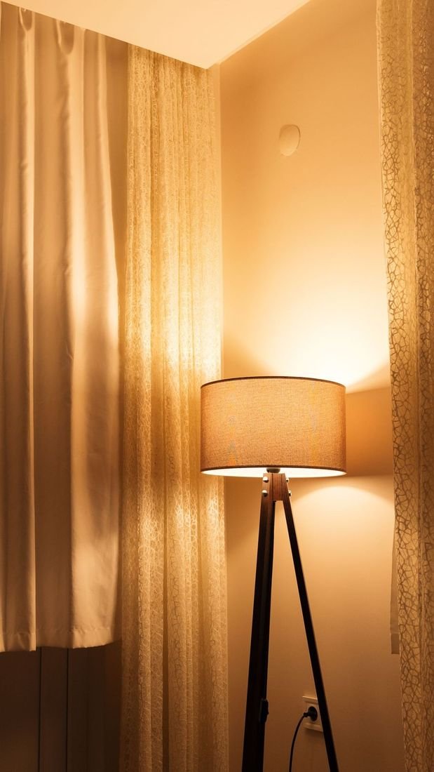 TikTok frame: a floor lamp glowing beside sheer curtains