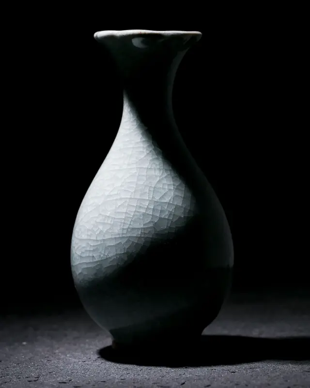 A crackle-glaze vase in a single beam of light