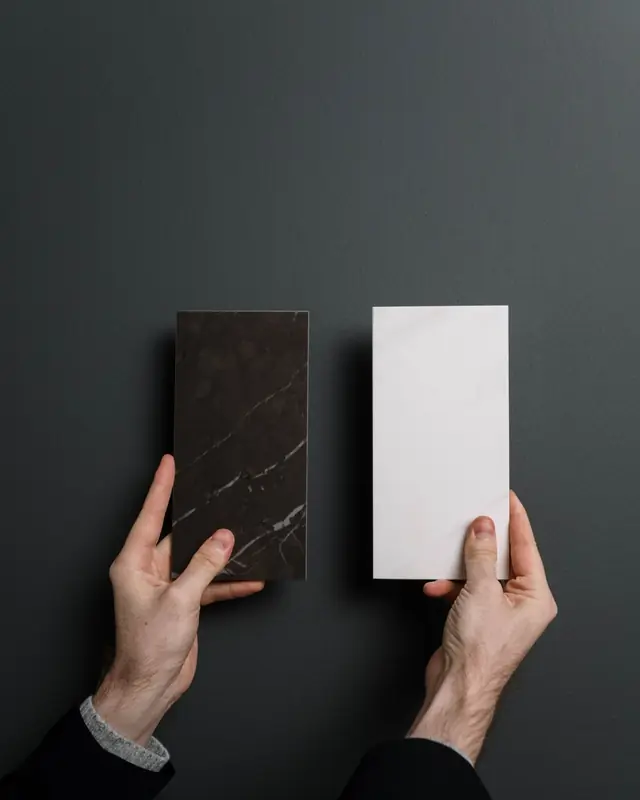 Hands holding black and white marble samples