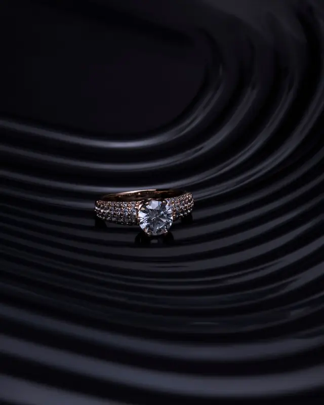 A diamond ring resting on rippled black
